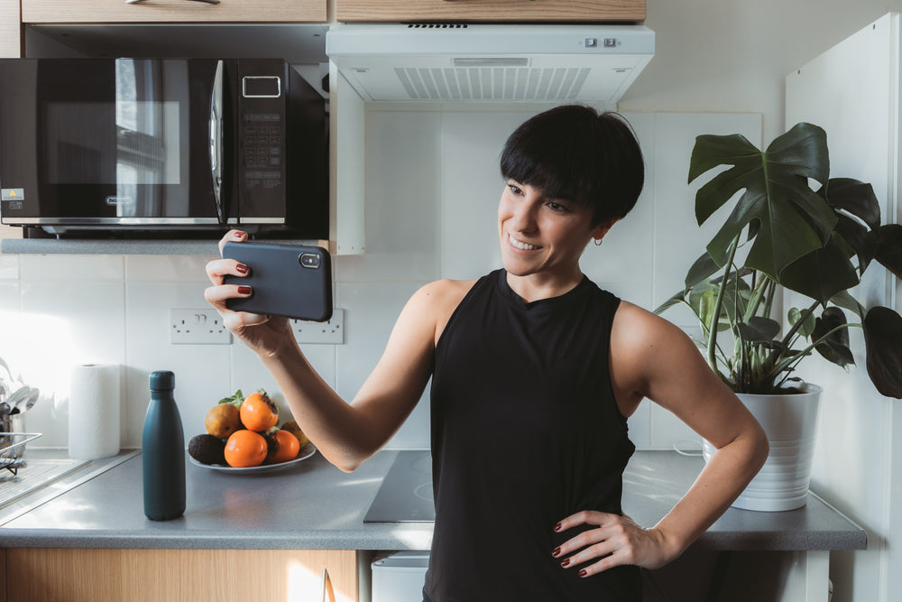 woman holds her cellphone horizontally to take a selfie