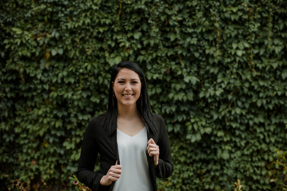 woman holds her lapels and looks at camera