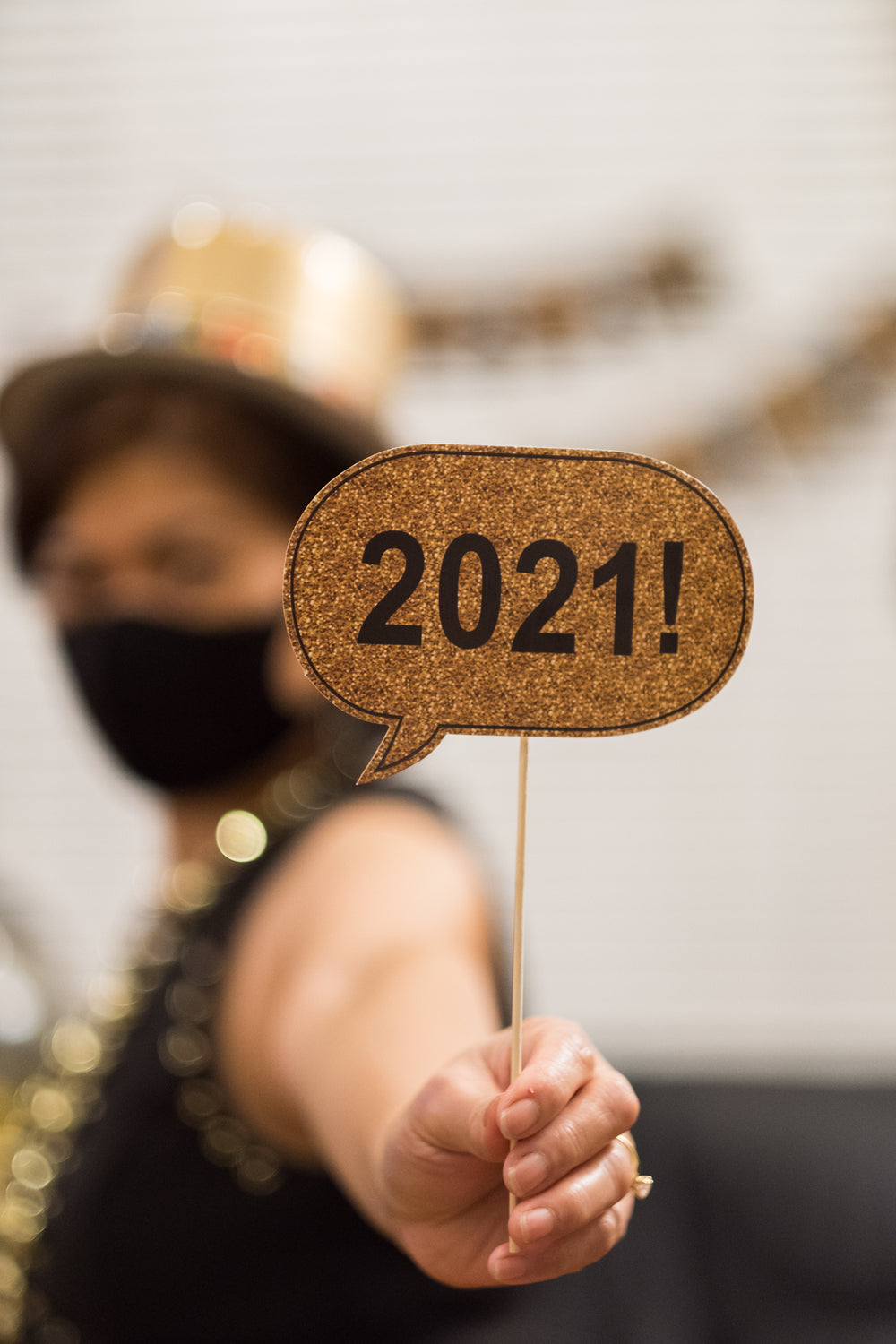 woman holds up small happy 2021 sign