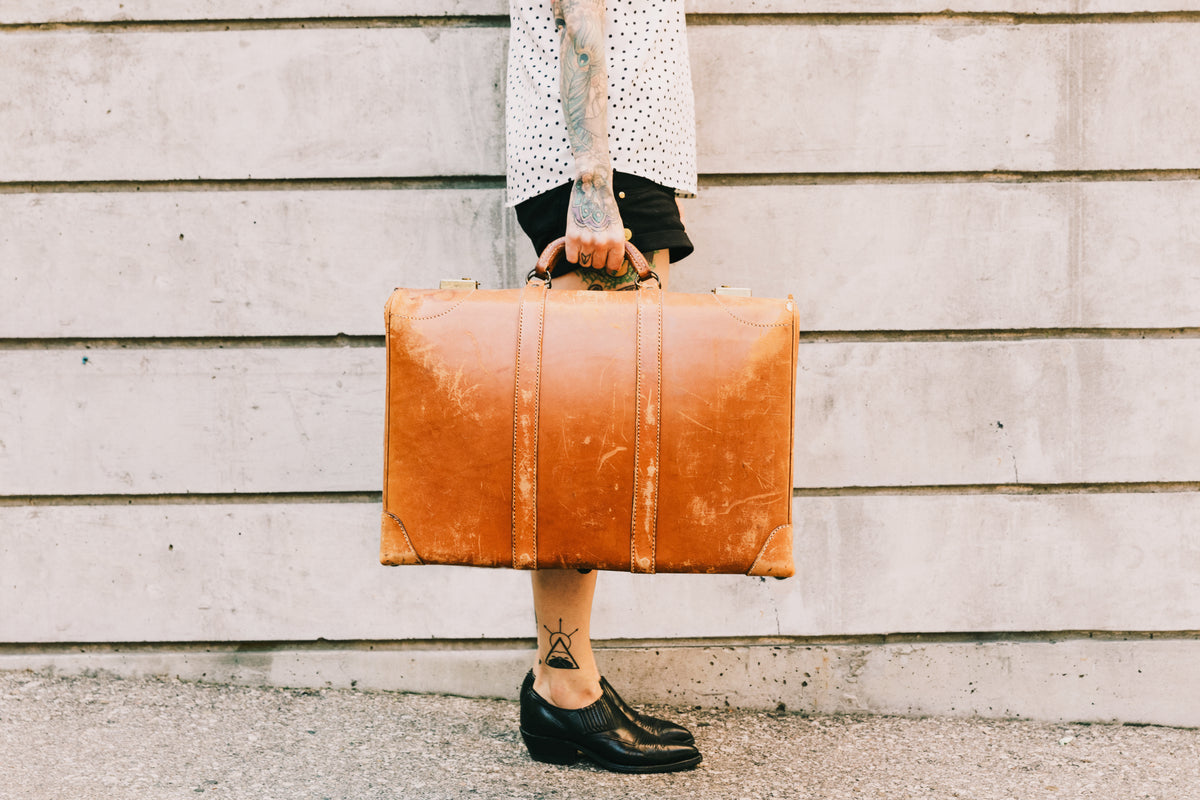 woman holds vintage suitcase