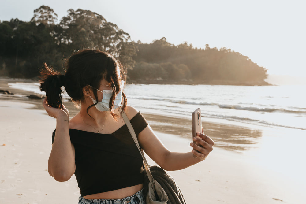 woman in a facemask takes a cellphone selfie