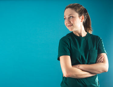 woman in a green plain shirt crosses her arms