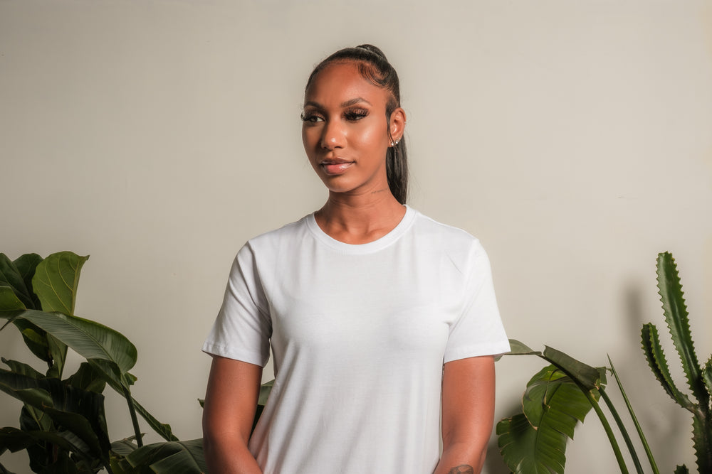 woman in a white shirt with house plants on either side