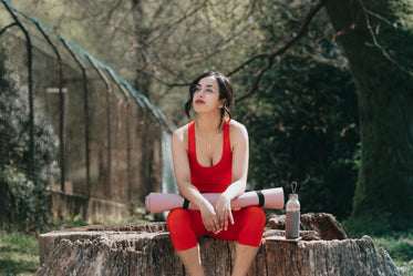 woman in athletic clothing sits outdoors