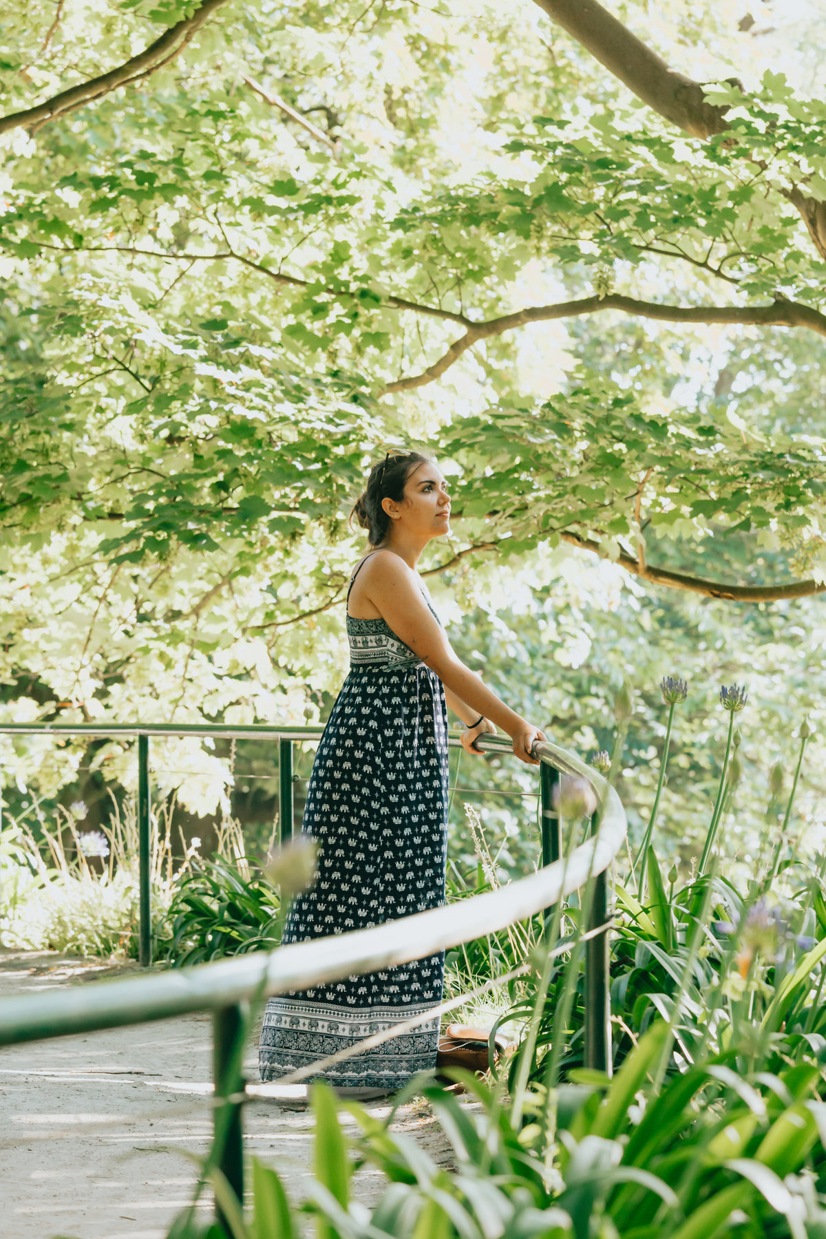 woman in blue and white sundress under green trees