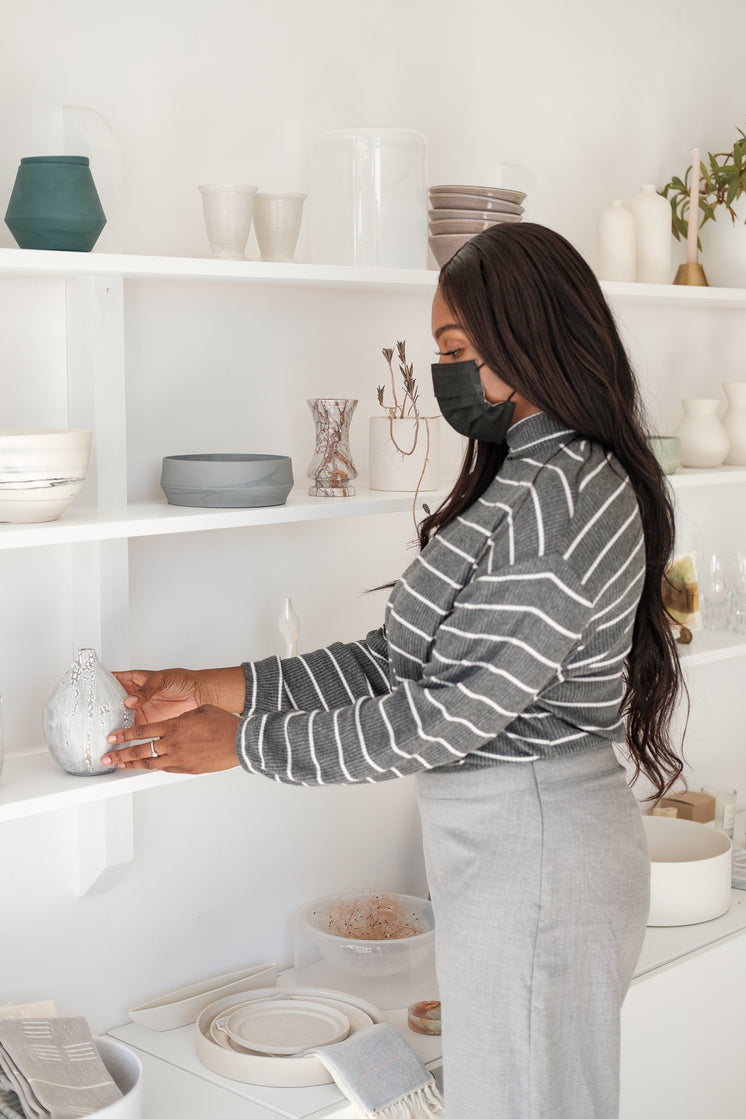 Woman In Face Mask Picks Up A Product