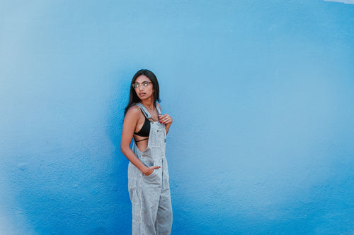 woman in front of blue wall looking back