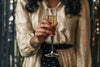 woman in gold dress holding champagne flute