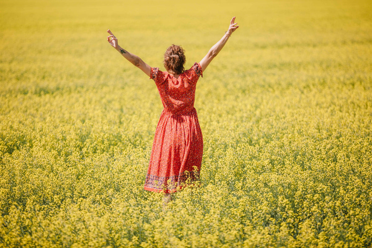 穿红衣服的女人站在黄色的田野里