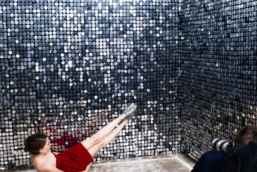 woman in red on floor stretches legs across mirror wall