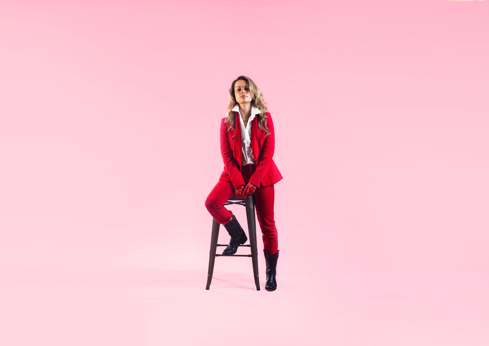 woman in red perches on stool