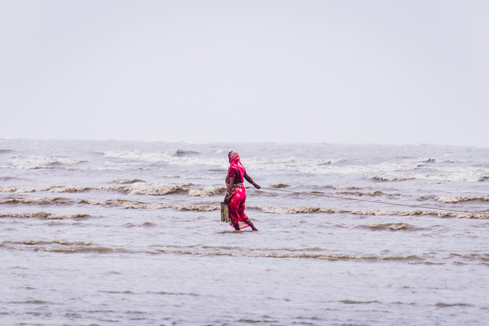 woman in red walking through shallow water