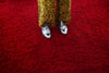 woman in silver oxfords crossing red shag carpet