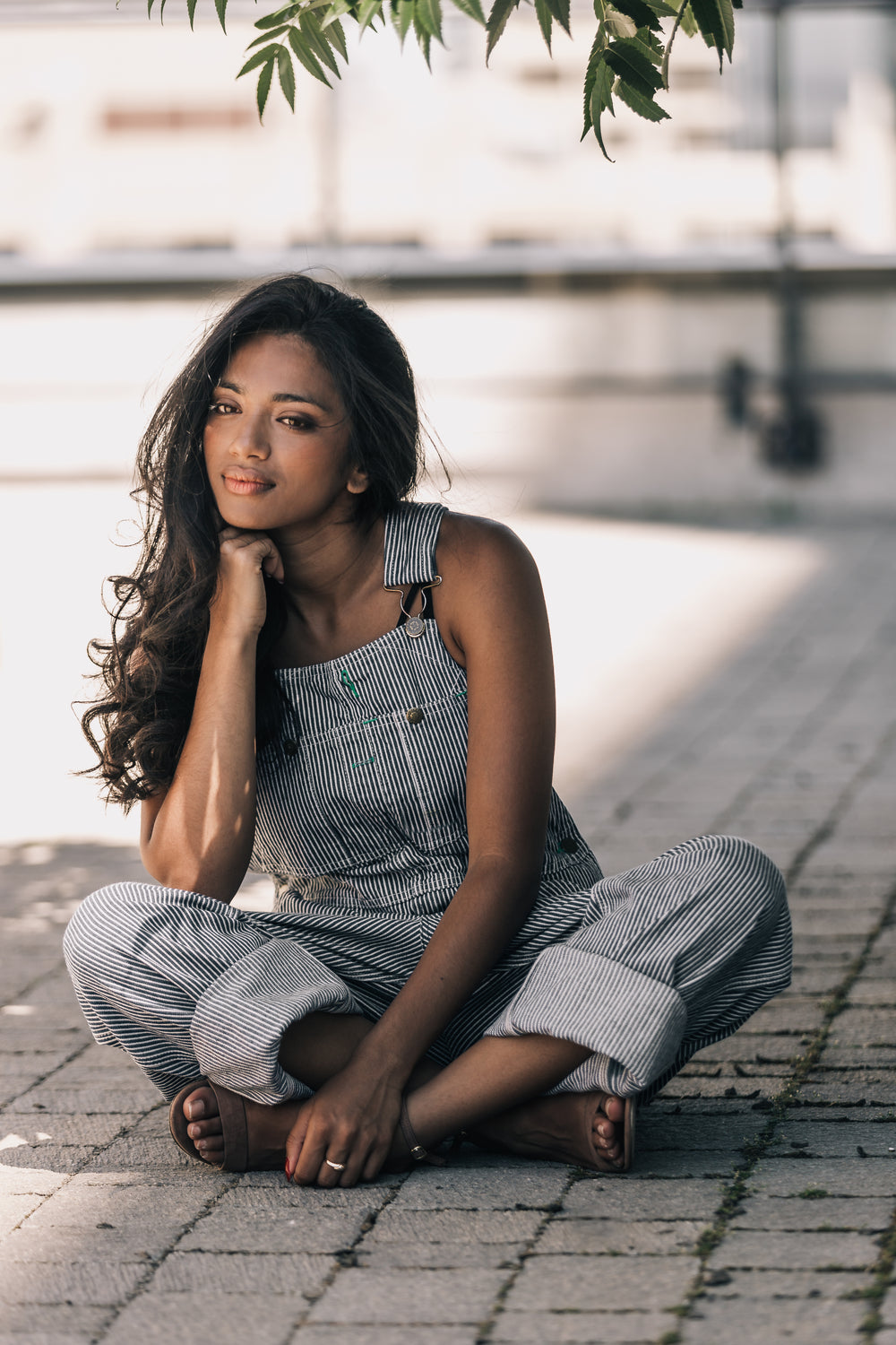 woman in striped overalls sitting cross legged