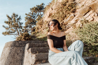 woman in sunglasses sits on stone steps