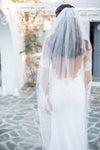 woman in wedding dress stands with her back to the camera