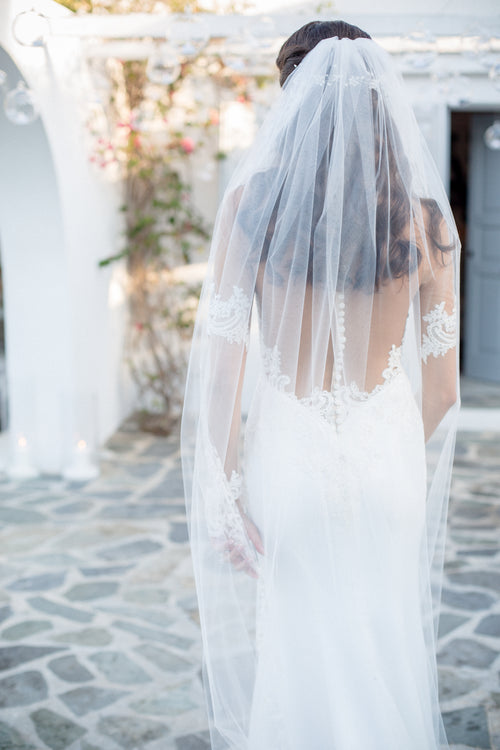woman in wedding dress stands with her back to the camera