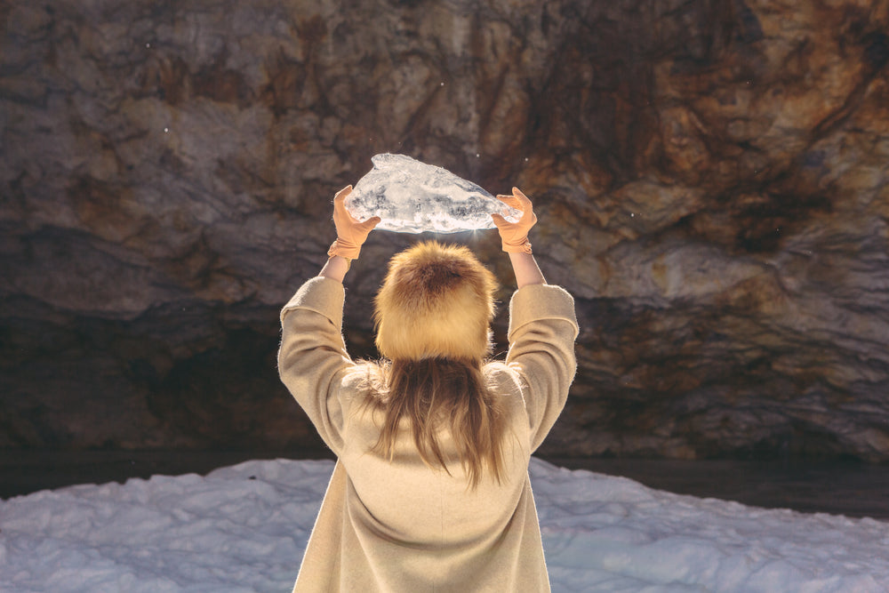 woman in winter fashion holding ice above