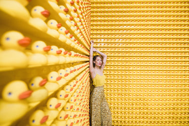 woman in yellow with rows of rubber ducks