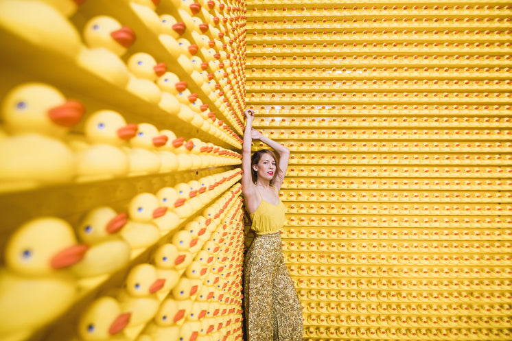 Woman In Yellow With Rows Of Rubber Ducks