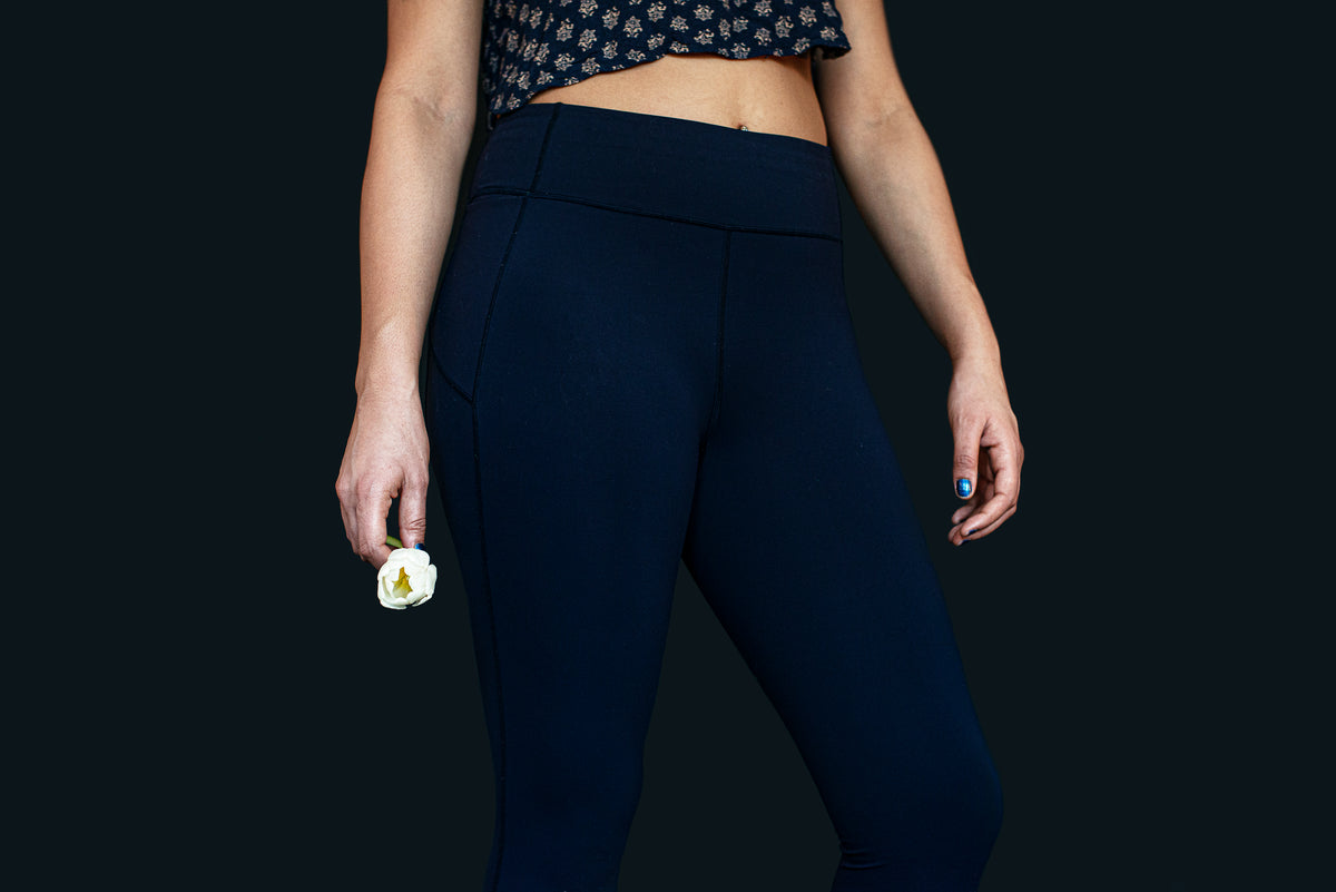 woman in yoga pants holding a single flower