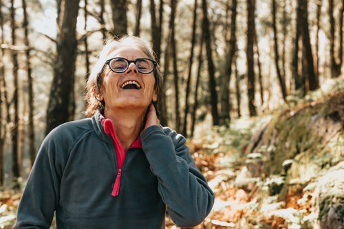 woman laughs while outdoors in a forest