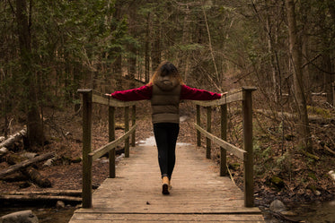 woman leans on railing on a bridge