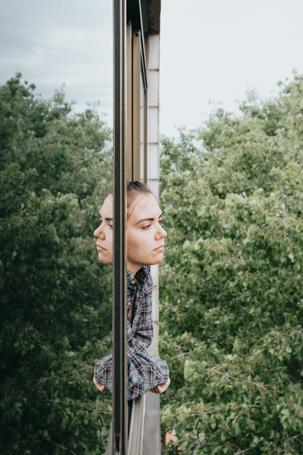 woman leans out a window and takes in the view below