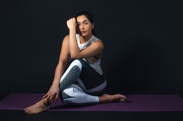 woman lens on hand while sitting on yoga mat