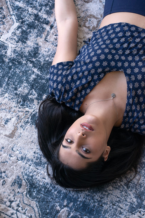 woman lies on patterned blue rug
