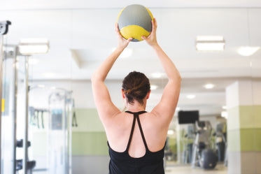 woman lifting fitness ball