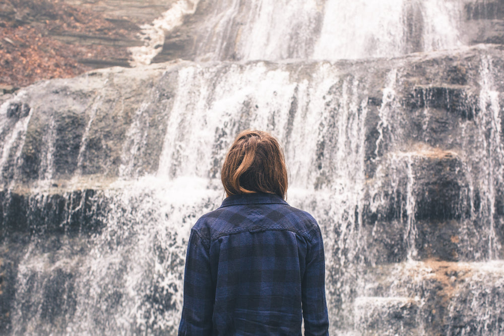 woman looking at waterfall