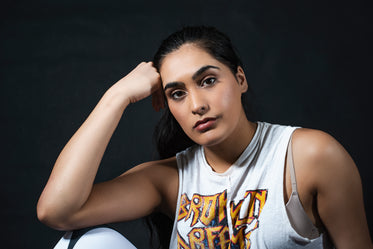 woman looks at camera and rests head on hand