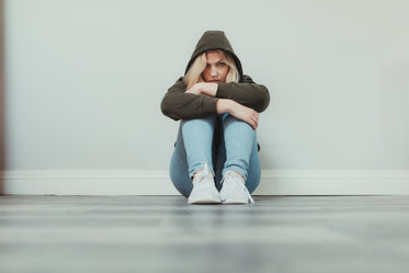 woman looks at the camera over her knees