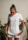 woman looks down and adjusts her white t shirt
