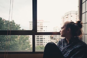 woman looks out a window to the view below