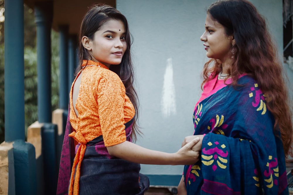 woman looks over shoulder holding another womans hand