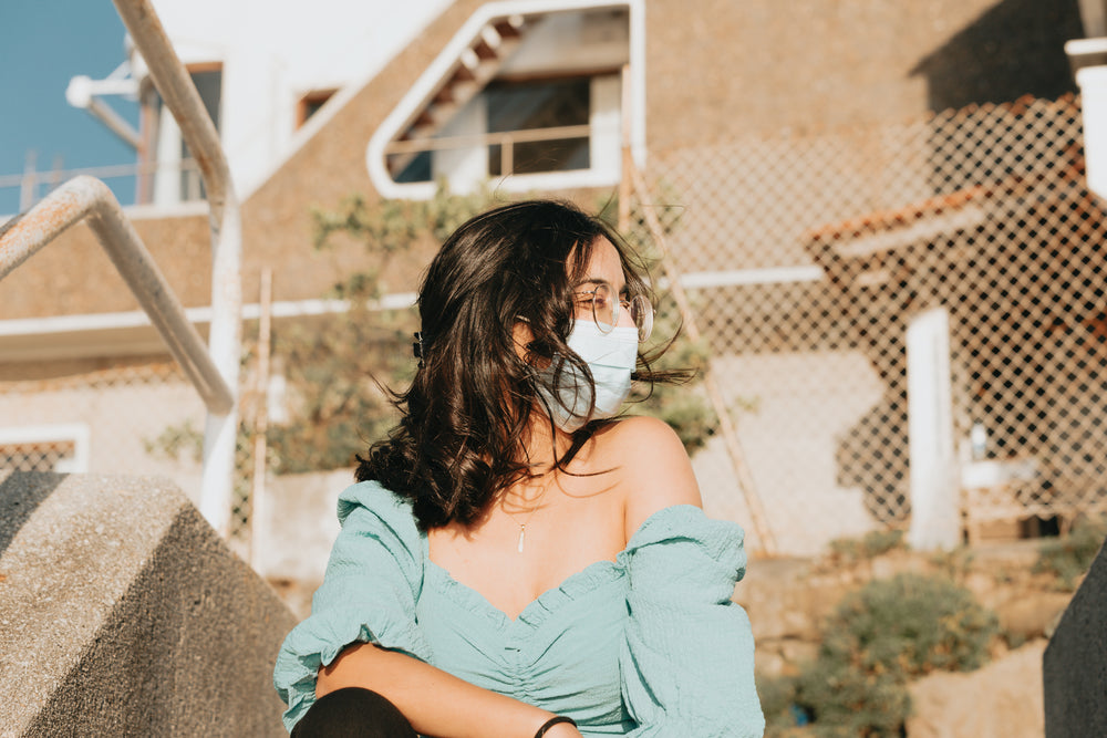 woman looks right and squints while wearing a facemask