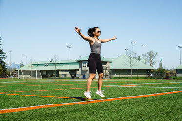 woman mid jumping jack floats above green grass