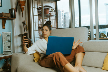 woman on a couch looks at her cell phone