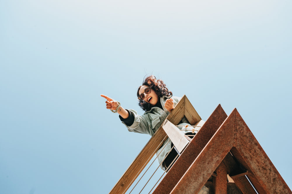 woman on a wooden deck points to something out of frame