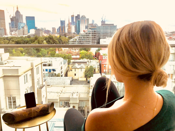 Woman On Balcony Looks Over City