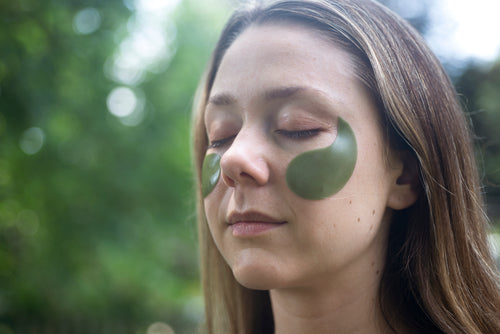 woman outdoors with her eyes closed with eye patches