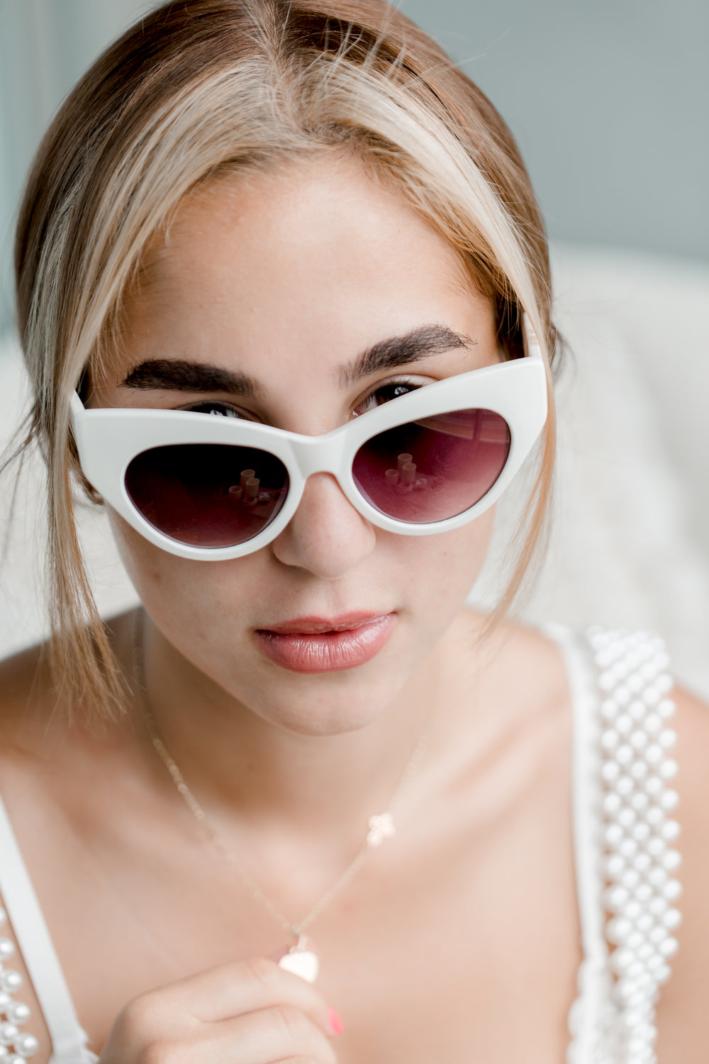 woman peeking over her sunglasses