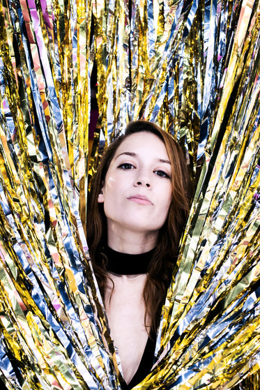 woman peeks through silver and gold