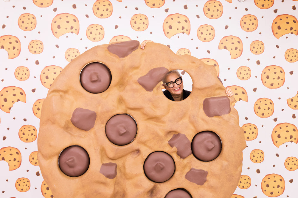 woman peering through a giant cookie
