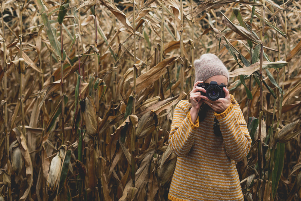 woman photographs field in fall