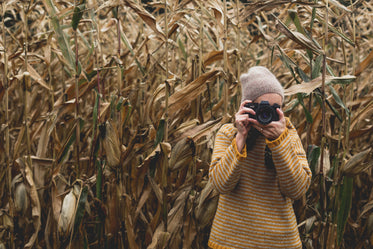 woman photographs field in fall