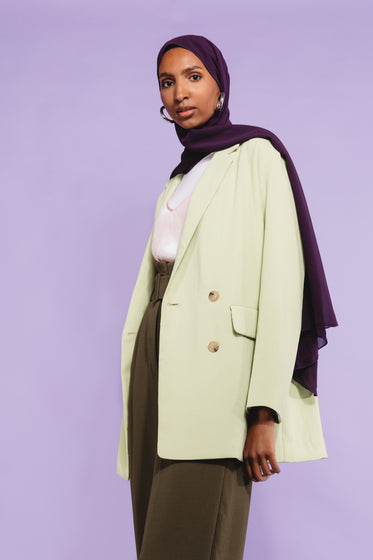 woman poses in green and purple