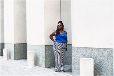 woman poses near city building